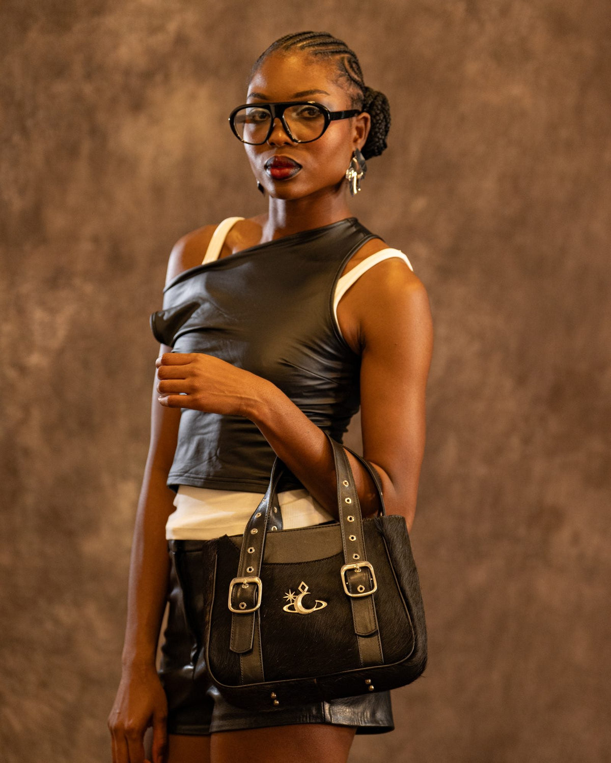 Bolso Nocturne de Luna Vesper, Sostenido con la mano delante de la cadera, de frente y a plena luz; se ve entero