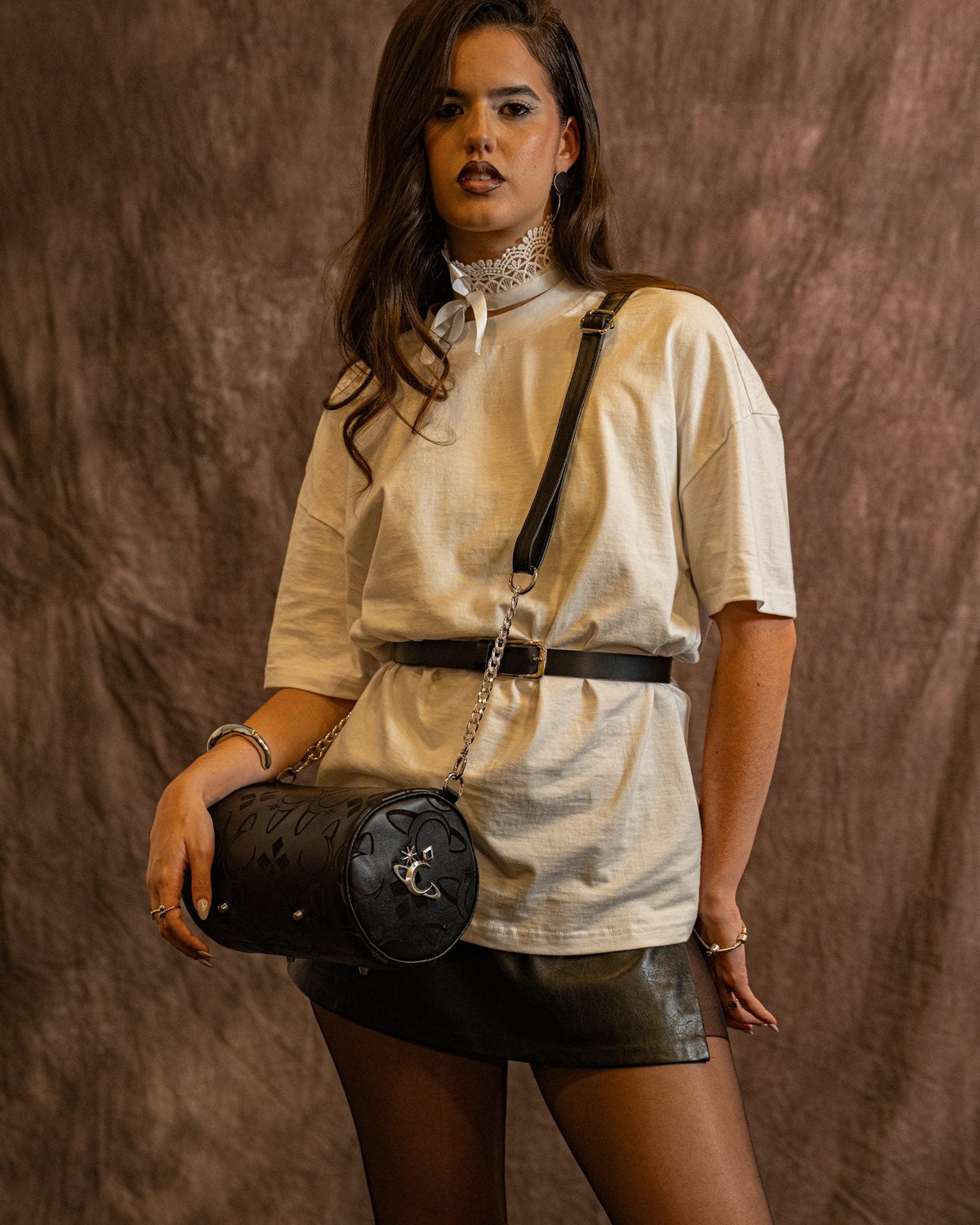 Bolso Obsidian de Luna Vesper, Cruzado al cuerpo, sujeto con la mano a la altura de la cadera; plano de tres cuartos