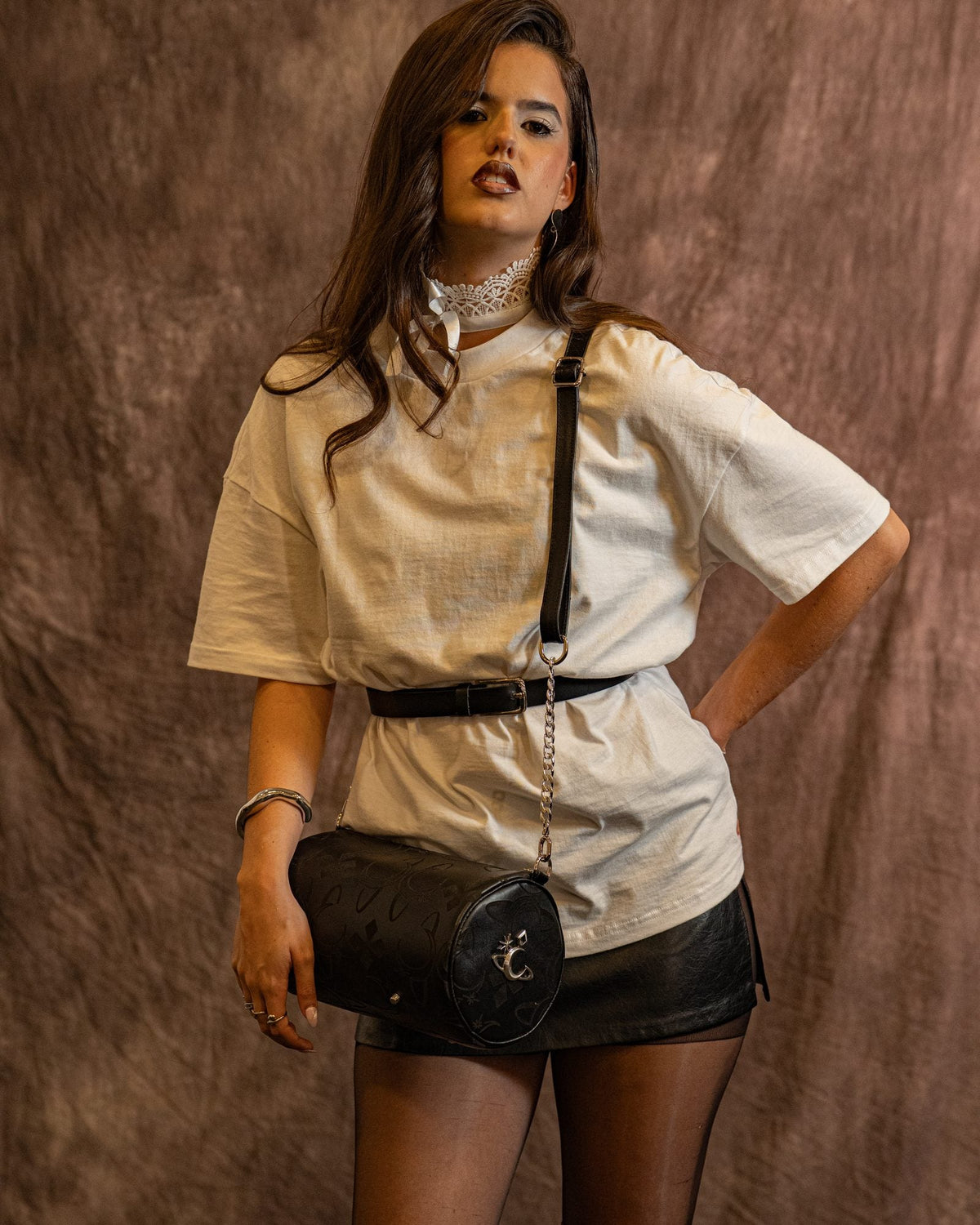 Bolso Obsidian de Luna Vesper, Cruzado al cuerpo sobre la cadera, la modelo con la mano en la cintura; se ve entero de perfil