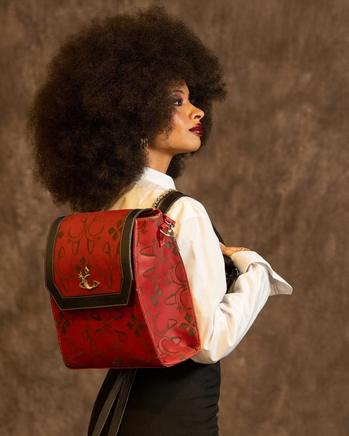 Bolso Red Shift de Luna Vesper, Llevado a la espalda, modelo de perfil; bolso completo y con la cara de la solapa hacia camar